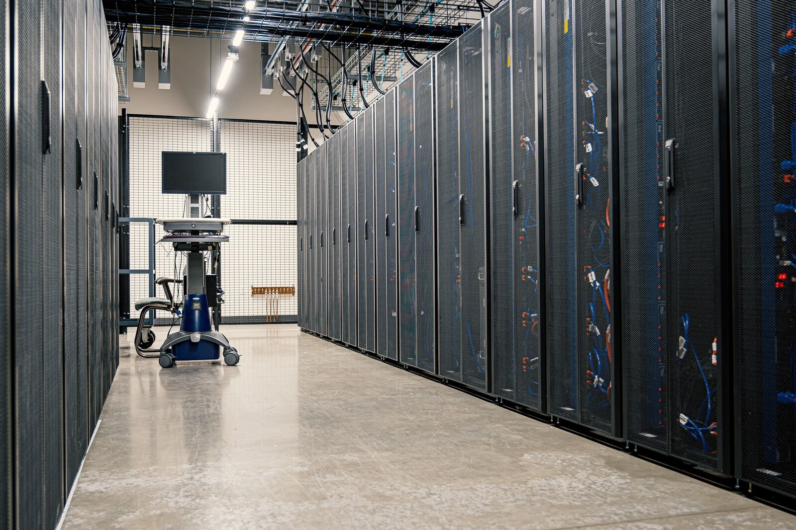 Rows of server racks in a data center corridor.
